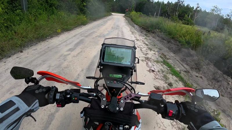 Rutted sandy dirt road over the handlebars